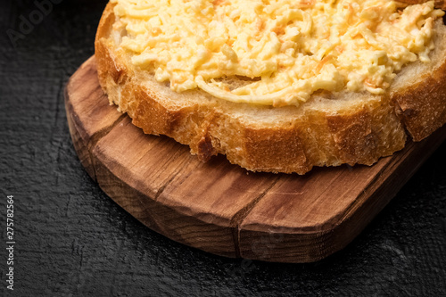 grated cheese sandwich with garlic on a slice of French baguette. Cooking snacks. Close up