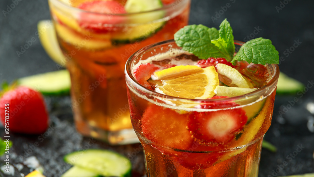 Refreshing Pimms Cocktail with Fruit and vegetables on rustic black table Refreshing Pimms Cocktail with Fruit and vegetables on rustic black table