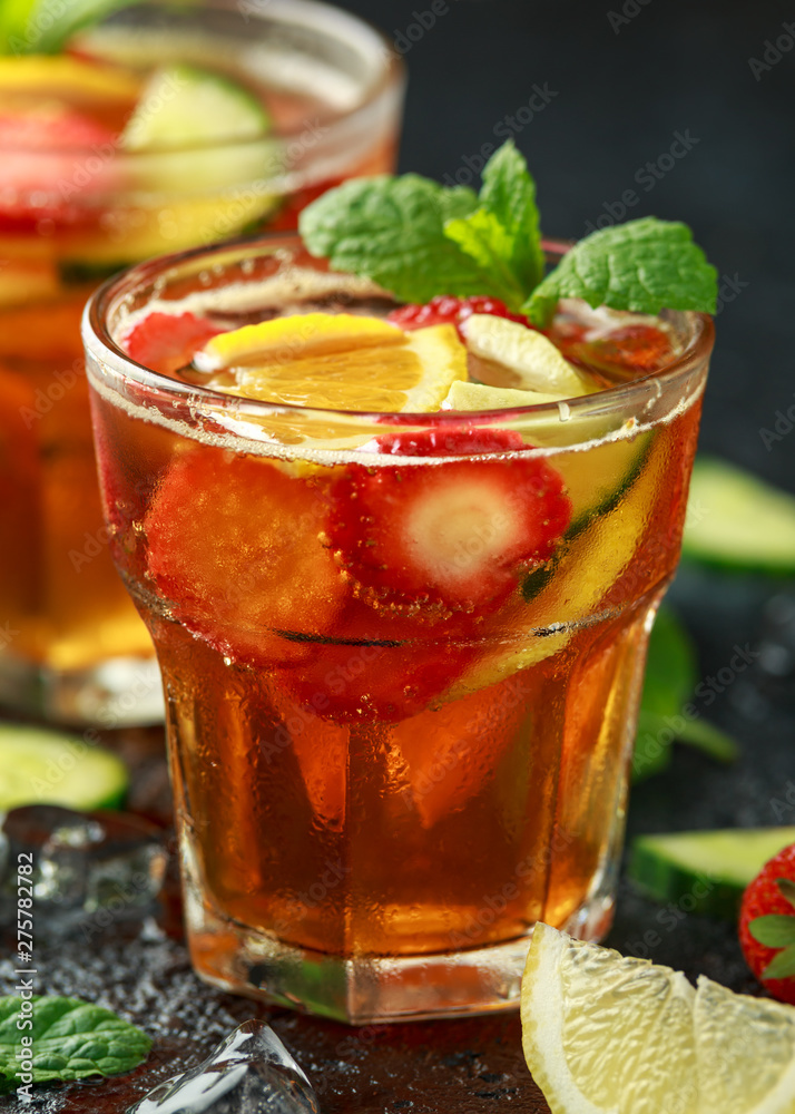 Refreshing Pimms Cocktail with Fruit and vegetables on rustic black table Refreshing Pimms Cocktail with Fruit and vegetables on rustic black table
