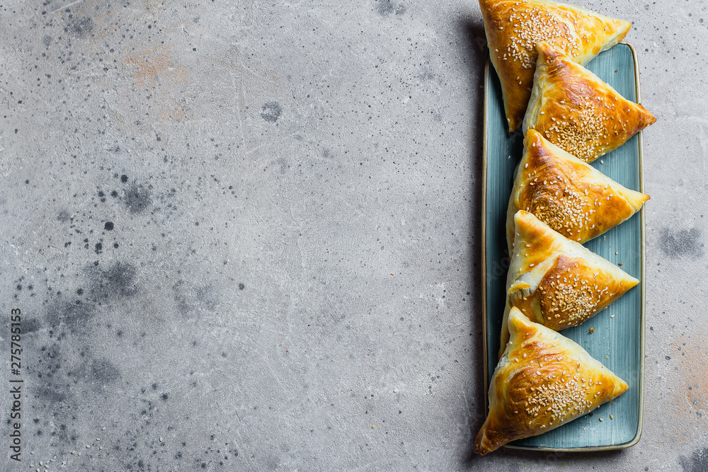 Delicious samosas samsa with meat, glass of tea on wooden table background, top view. East Asian Dish. Ramadan food Delicious samosas samsa with meat, glass of tea on wooden table background, top view. East Asian Dish. Ramadan food