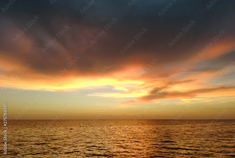 a beautiful sunset at varakkal beach with dark shining colouds ocean coast reflection on the sea making a nature art horizon