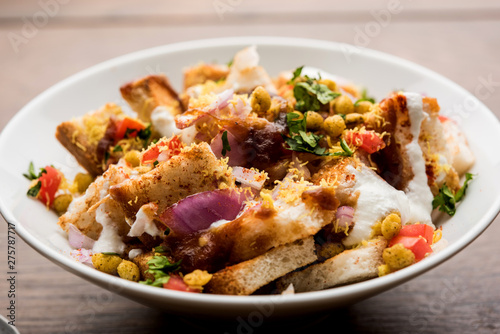 Bread chaat/chat is a yummy starter/appetizer from India, served in a bowl garnished with tomato, sev and coriander and masala. selective focus