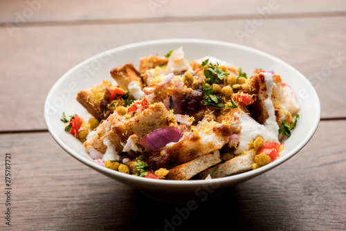 Bread chaat/chat is a yummy starter/appetizer from India, served in a bowl garnished with tomato, sev and coriander and masala. selective focus