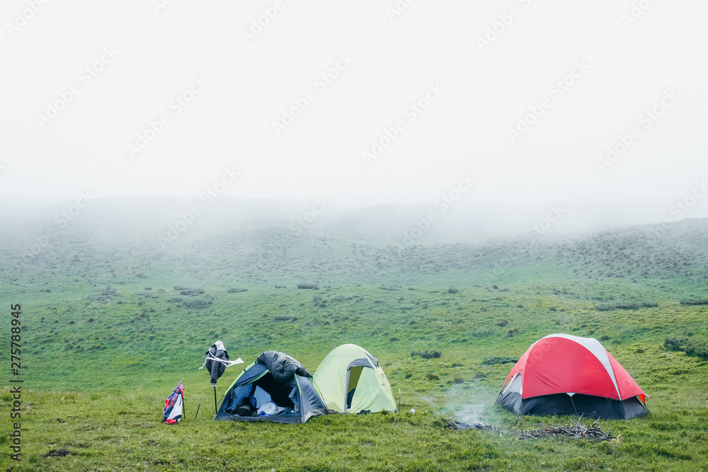 A few camping tents in the mountains on a foggy day