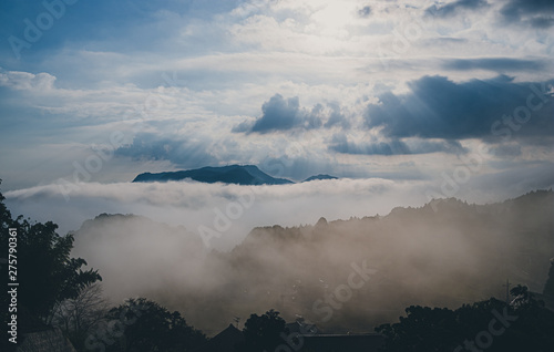 A large mountain in the distance and a cloud in the vicinity