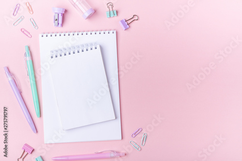 School background with notebooks and pastel colorful study accessories on pink background Back to school concept