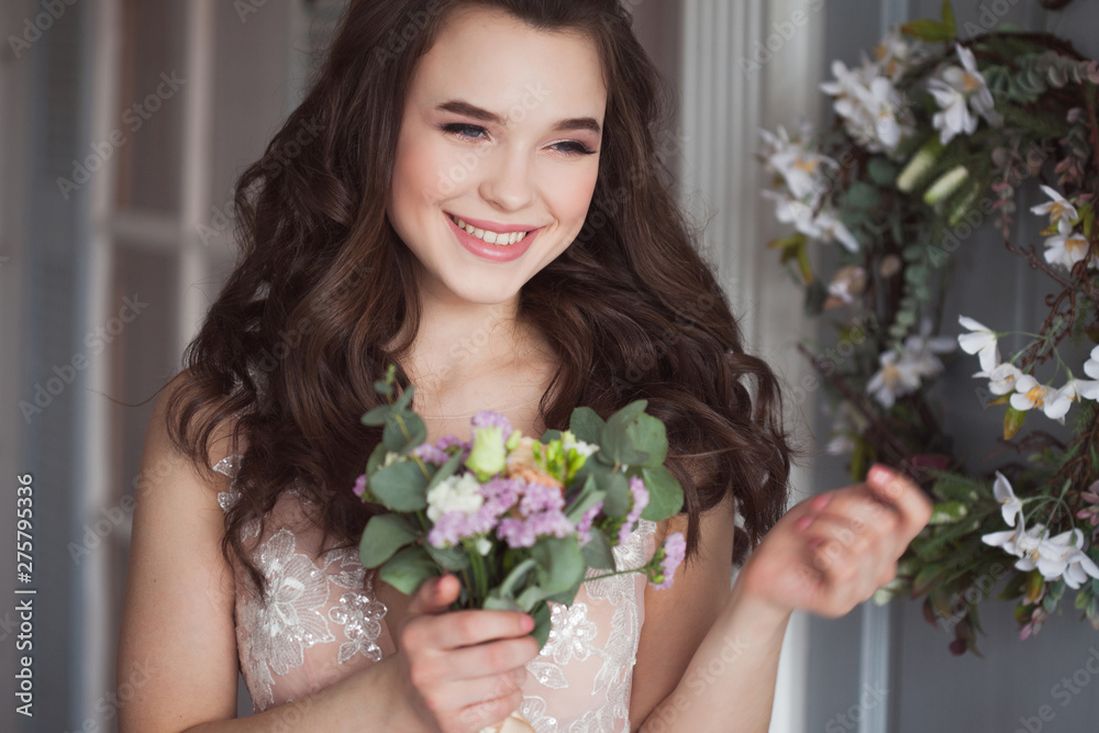 lovely young woman brunette n a Lacy pink dress. Attractive bride with a bouquet of flowers