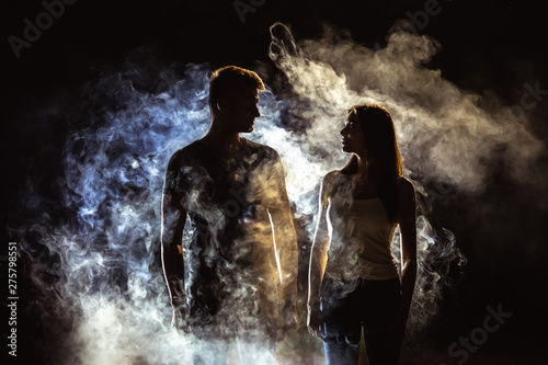 The couple standing near the smoke in the dark