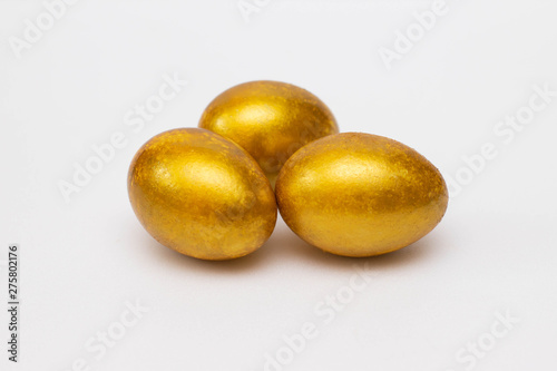 Golden eggs on a light background. Concept of wealth