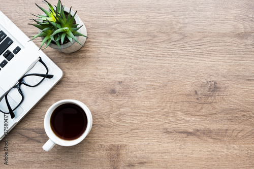 Fotografija Wood office desk table with laptop computer, cup of coffee and supplies