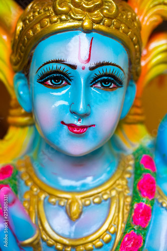 Closeup Portrait of Hindu God Krishna in colorful high glossy statue.