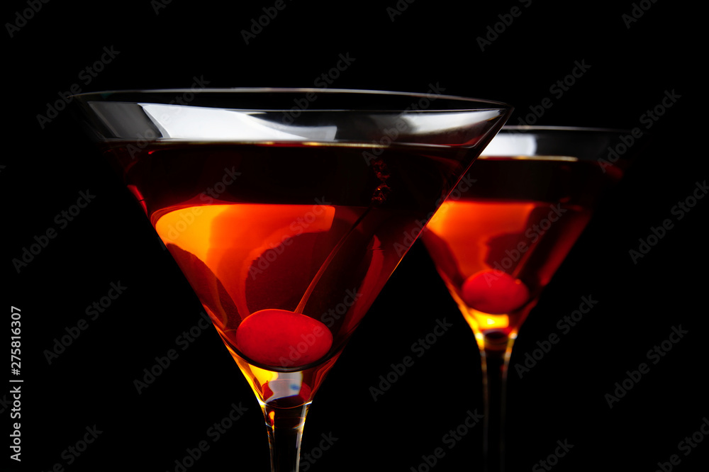 Closeup manhattan drinks with red cherry on black table Closeup manhattan drinks with red cherry on black table