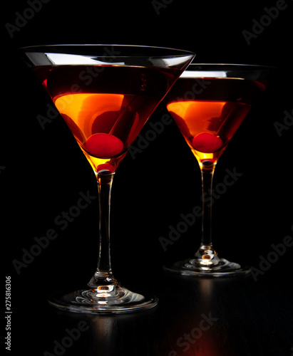 Manhattan drinks with red cherry on black