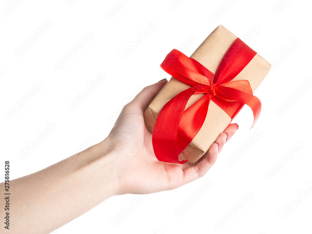 Hand woman holding gift box on isolated on white background. Gift wrap craft paper and red ribbon. Hand woman holding gift box on isolated on white background. Gift wrap craft paper and red ribbon.