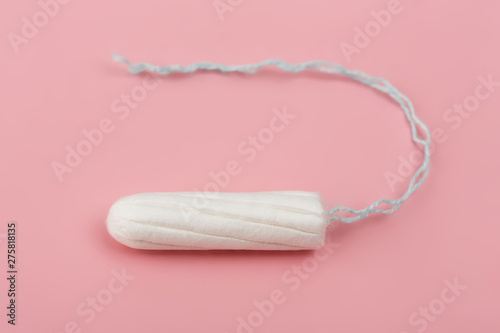 Medical female tampon on a pink background. Hygienic white tampon for women. Cotton swab. Menstruation, means of protection. Tampons on a red background. photo