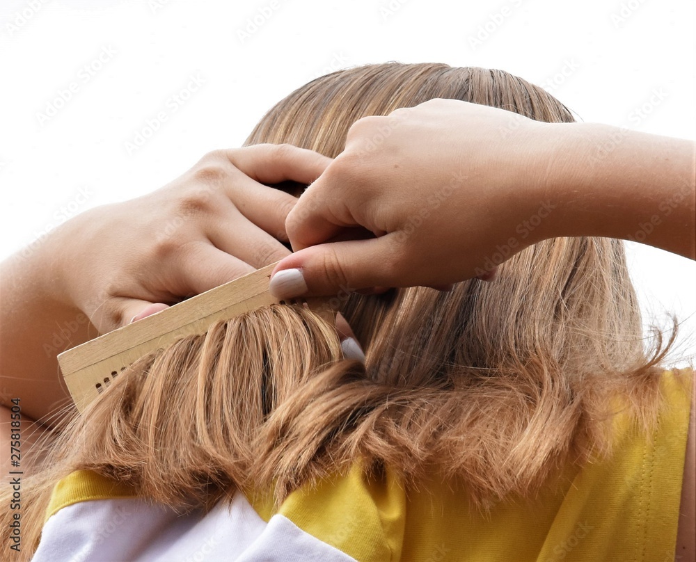 Obraz premium blonde girl combing her long straight hair with a wooden comb