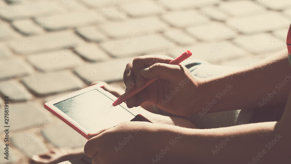 Obraz premium preschool girl with drawing tablet on a sunny day
