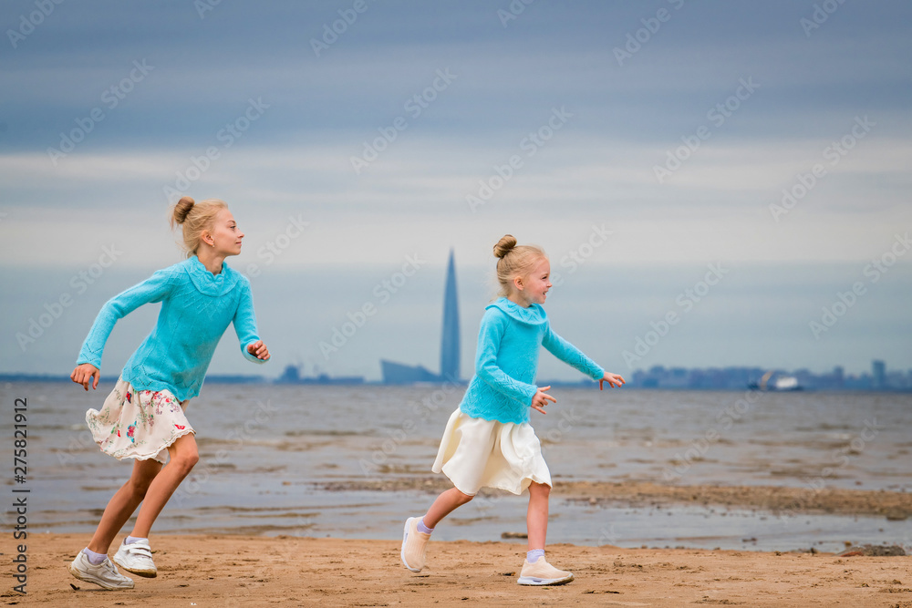 girls running along the bay