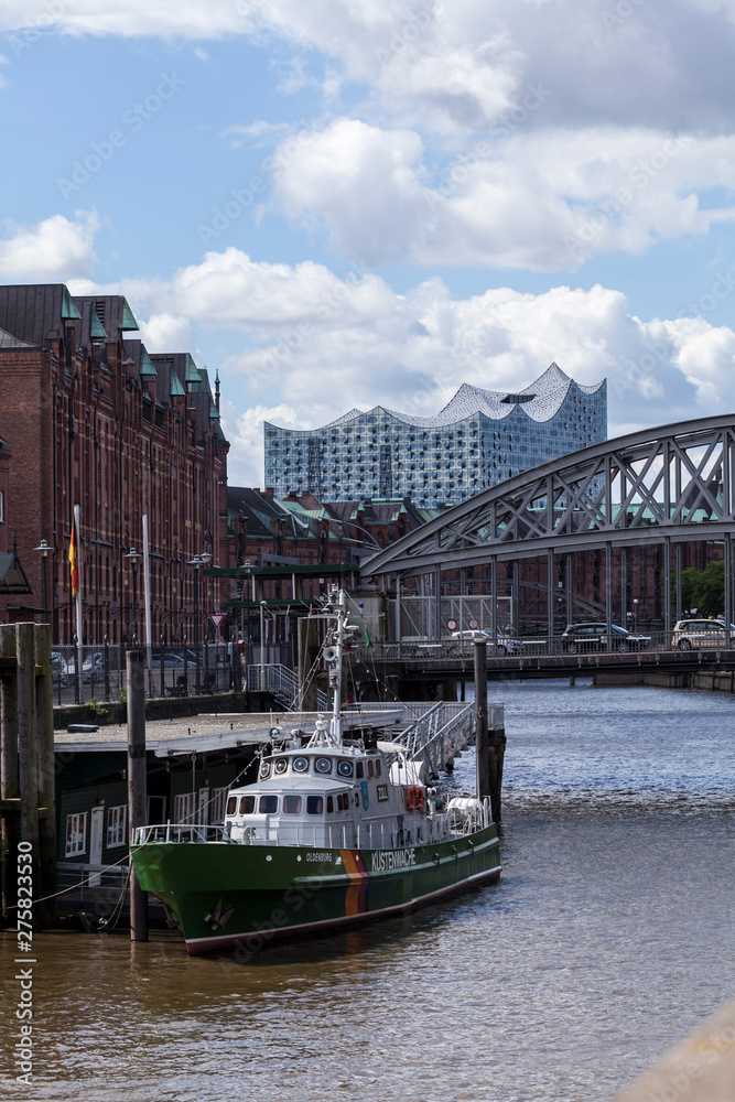 Blick auf die Elbphilharmonie und im Vordergrund ein Schiff der Küstenwache in Hamburg