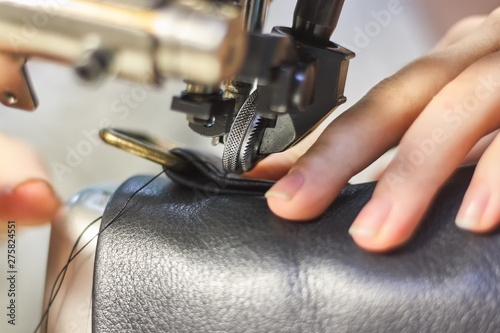 Wallpaper Mural Sewing machine in a leather workshop in action with hands working with a leather details Torontodigital.ca