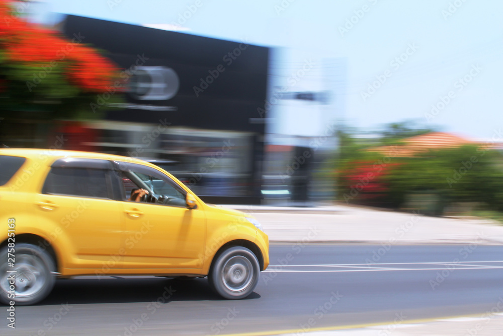 Yellow car moving fast along the street