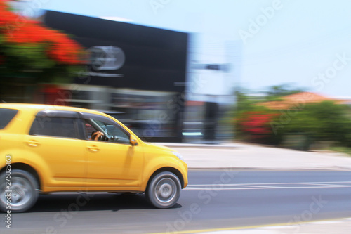 Yellow car moving fast along the street