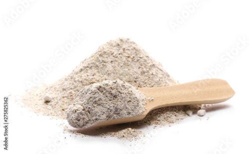Integral rye flour pile in wooden spoon isolated on white background