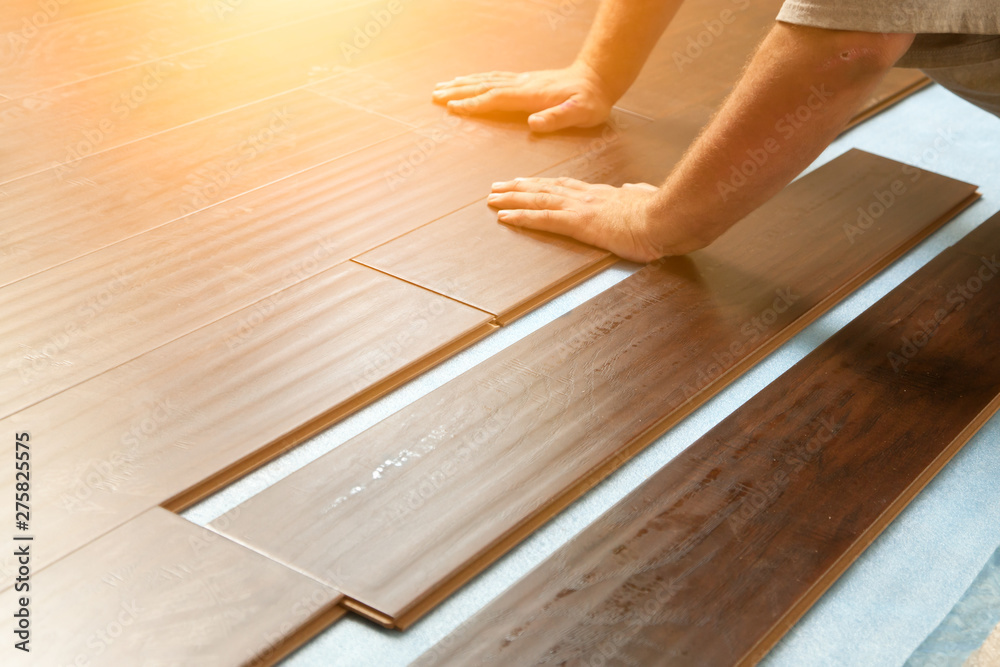 Man Installing New Laminate Wood Flooring - obrazy, fototapety, plakaty 