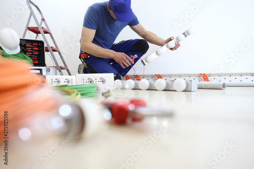 electrician at work with nippers in hand cut the electric cable, install lamps at home, electric circuits, electrical wiring