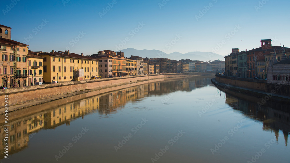 Colorful old houses with reflection in a river at Pisa, Tuscany, Italy, Europe.