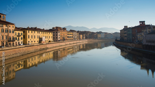 Colorful old houses with reflection in a river at Pisa, Tuscany, Italy, Europe.