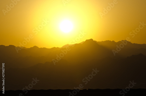 Orange sky of sun during sunset above mountains in Sinai desert  Egypt