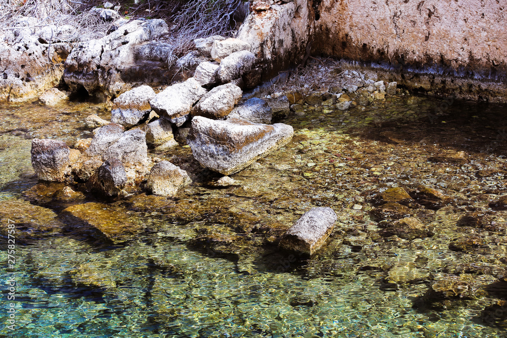 Clear seawater bluish-green, translucent and visible sea bottom; clean water in different beautiful colors on a rocky shore Clear seawater bluish-green, translucent and visible sea bottom; clean water in different beautiful colors on a rocky shore