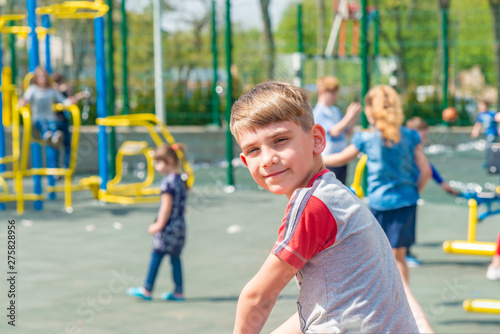 A boy on the playground, a portrait of a child against the backdrop of children's swings and amusements.