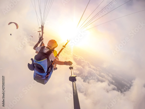 Paragliding in the sky. Paraglider tandem flying over the sea with blue water and mountains in bright sunny day. Aerial view of paraglider and Blue Lagoon in Oludeniz, Turkey. Extreme sport. Landscape photo