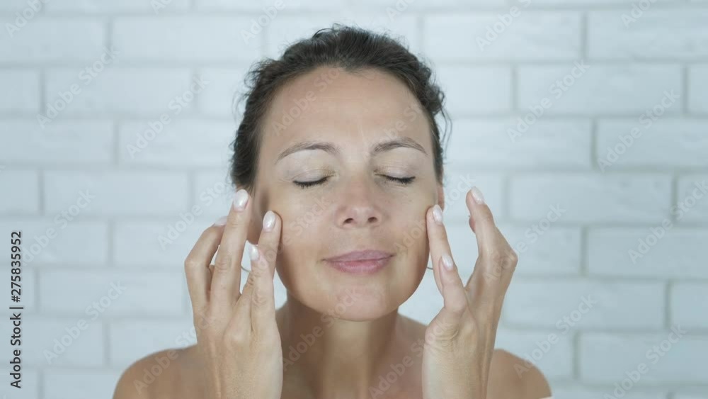 Beauty products for face. Cute woman applies cream to her face. Beauty products for face. Cute woman applies cream to her face.