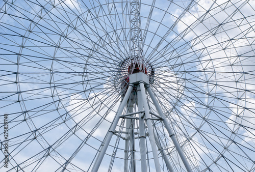 "Ferris Wheel" against a cloudy blue sky