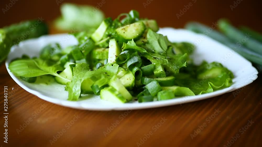 fresh salad of cucumbers and greens in a plate on a wooden fresh salad of cucumbers and greens in a plate on a wooden