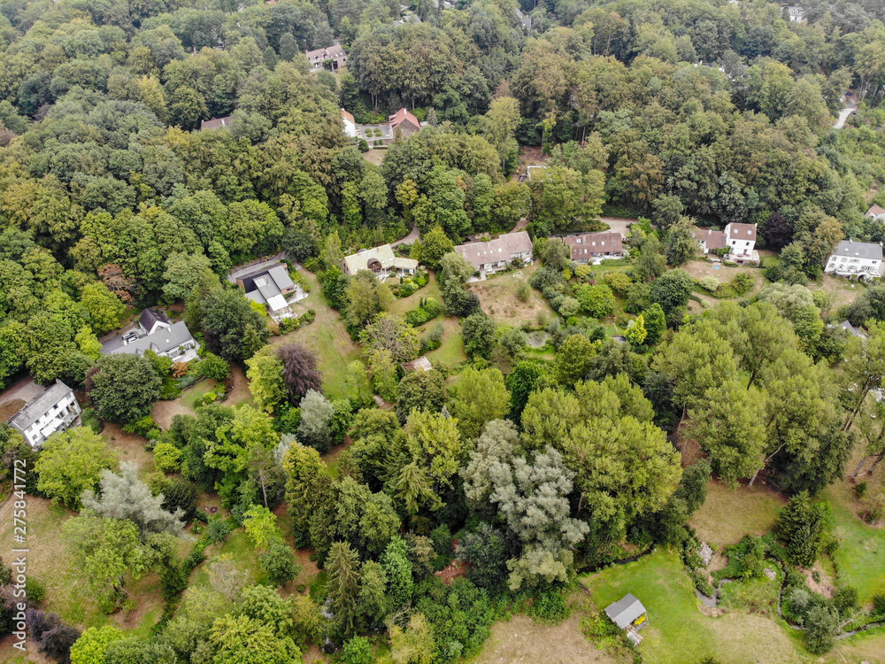 Aerial view of country side area in Walloon Brabant, Belgium, Luxury villas with garden surrounded by forest during autumn season