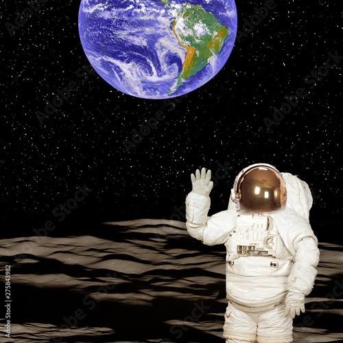 Astronaut on the moon. Blue fascinating earth on the background. Elements of this image furnished by NASA. photo