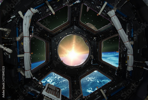 Fascinating sunrise on earth. Spaceship window view. Elements of this image furnished by NASA.