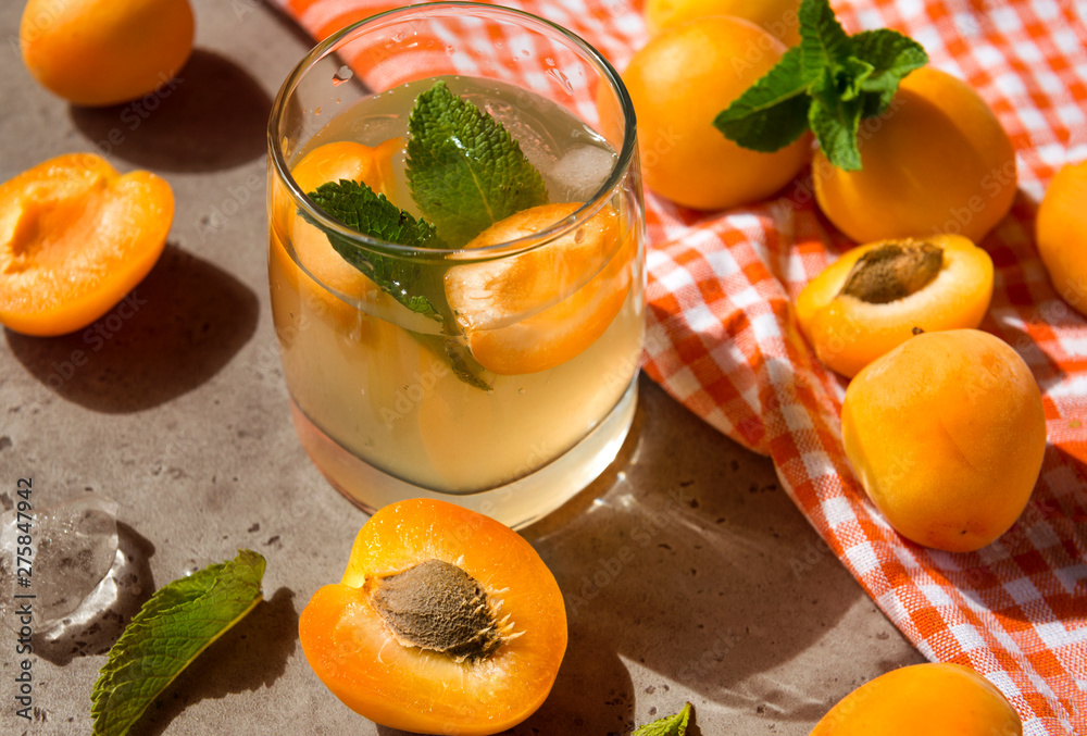 glass of apricot lemonade , fresh apricots ,apricot slices, mint, towel glass of apricot lemonade , fresh apricots ,apricot slices, mint, towel
