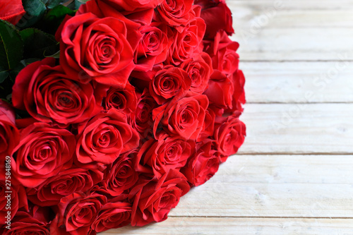 Fototapeta Naklejka Na Ścianę i Meble -  Bukiet czerwonych róż na drewnianym  stole