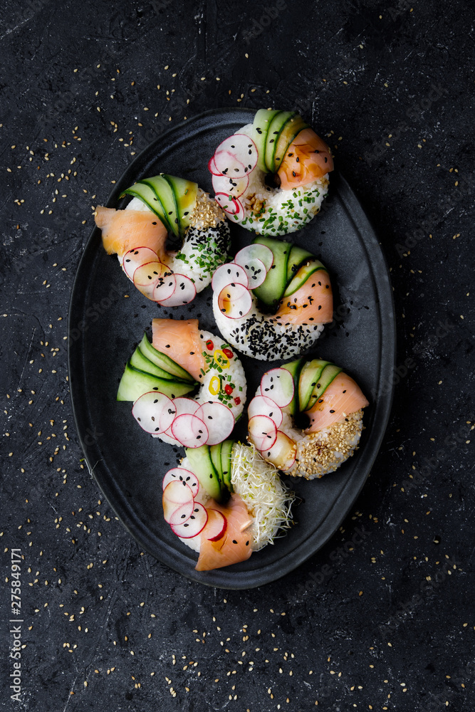 Sushi donuts on plate on dark background. Top view. Sushi donuts on plate on dark background. Top view.