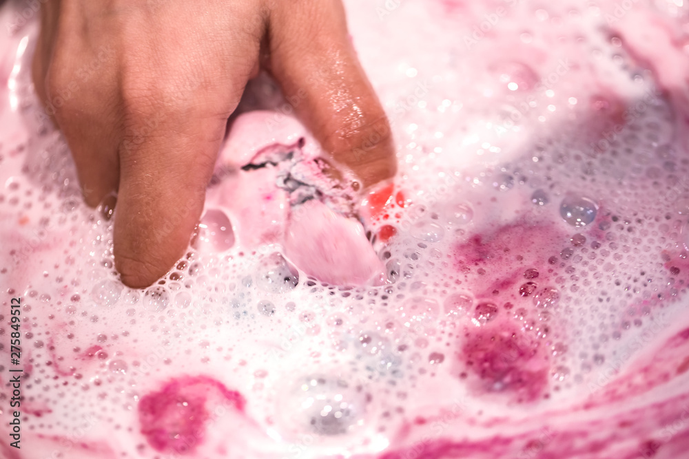 Fototapeta premium Bright natural fizzy bath bomb dissolves in the hands