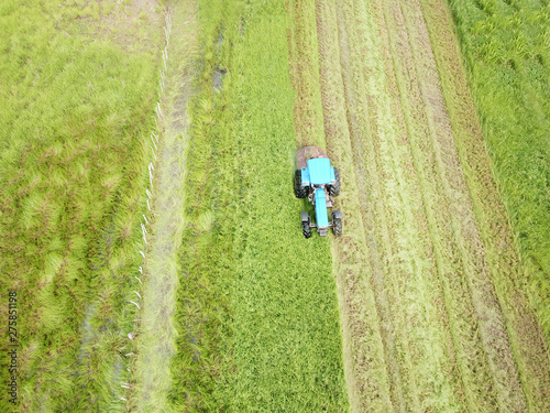 Aerial view of a tractor bush hogging on a field in a farm
