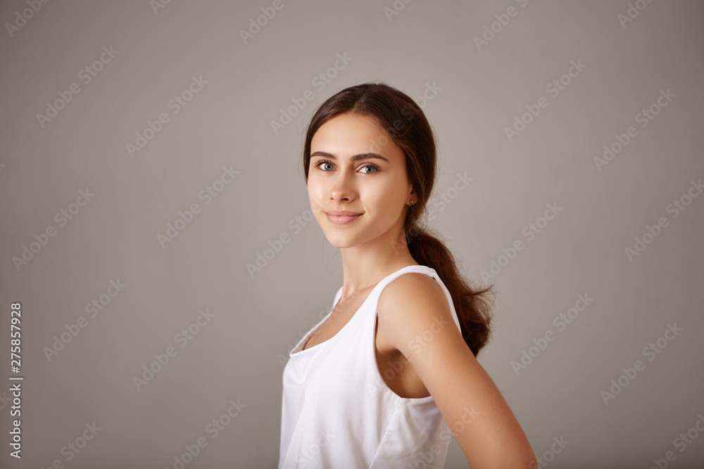 Positive human facial expressions, emotions, reaction and feelings. Studio image of gorgeous charming cheerful teenage girl with tanned perfect skin and slender body having joyful look, smiling Positive human facial expressions, emotions, reaction and feelings. Studio image of gorgeous charming cheerful teenage girl with tanned perfect skin and slender body having joyful look, smiling