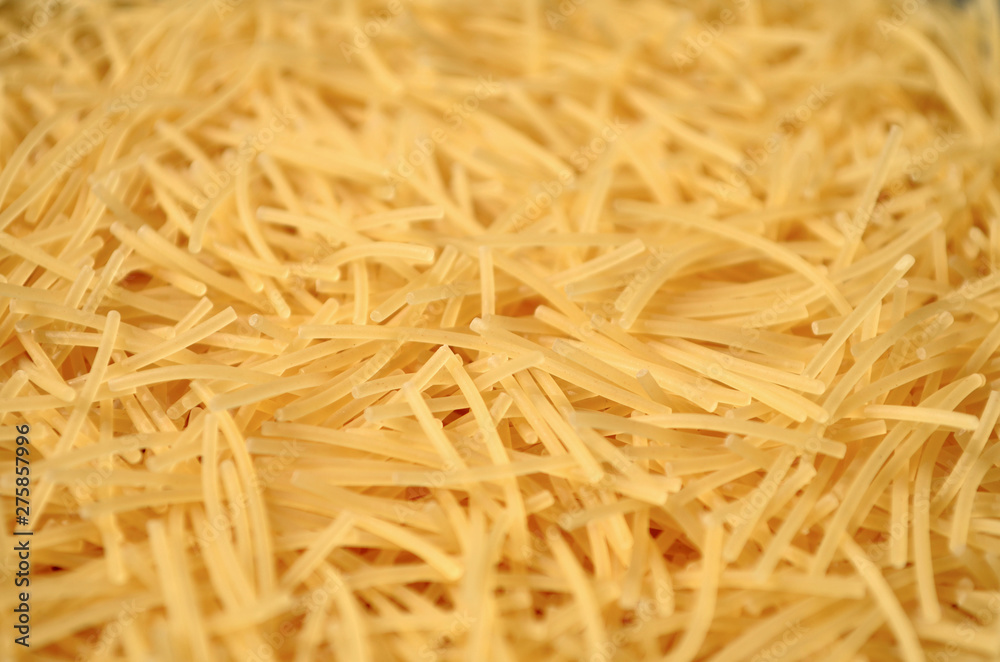 Dry uncooked vermicelli as a background texture. Close-up, shallow depth of field Dry uncooked vermicelli as a background texture. Close-up, shallow depth of field