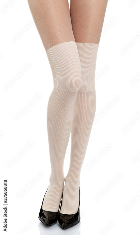 Woman with long legs wearing white stylish panty hose stockings and black high heels stands from the front side on white isolated background Woman with long legs wearing white stylish panty hose stockings and black high heels stands from the front side on white isolated background