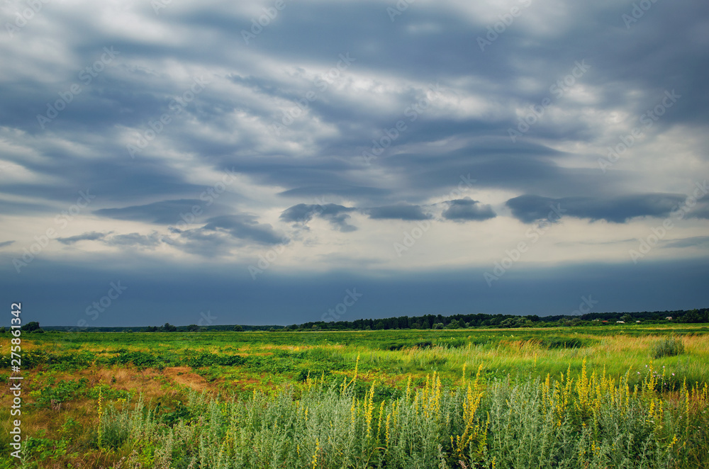 Obraz premium Dark rain storm clouds over the field